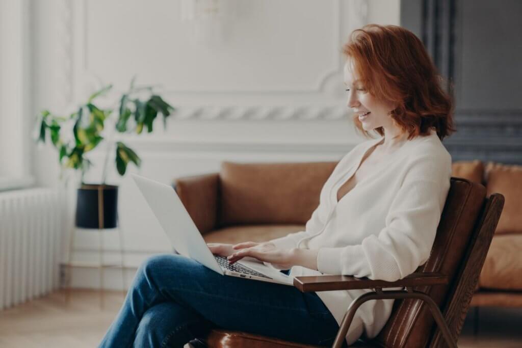 A woman reviewing employee contracts on her laptop